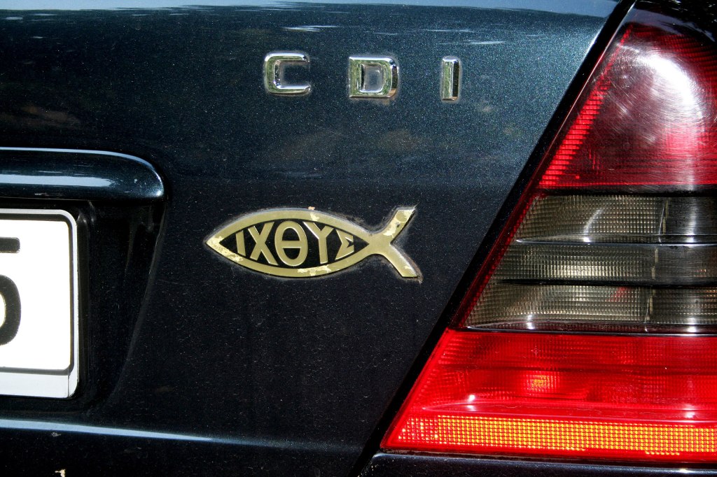 Symbole de foi en Jésus: un autocollant représentant un poisson avec le mot ichtus est collé à l'arrière d'une voiture
